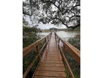 Picturesque wooden dock leading to a gazebo on the water with trees overhead at 2407 Edisto Ferry Rd, Edisto Island, SC 29438