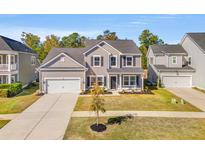 Charming two-story home features a well-manicured front yard and attached two-car garage at 244 Granton Edge Ln, Summerville, SC 29486