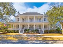 Stunning two-story home featuring a grand porch with white columns and professionally landscaped front yard at 301 Hidden Bottom Ln, Daniel Island, SC 29492