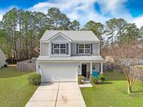Charming two-story home with a well-manicured lawn, garage, and inviting front porch at 302 Wynfield Forest Dr, Summerville, SC 29485