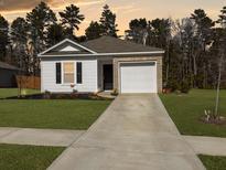 Charming single-story home with a well-manicured lawn, brick accents, and an attached garage at 386 Spruce Ivy St, Moncks Corner, SC 29461