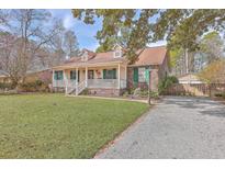 Charming home featuring a welcoming front porch, well-maintained lawn, and a gravel driveway at 634 Lakeside Dr, Moncks Corner, SC 29461