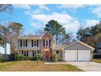 Charming two-story home with gray siding, brick accents, and a well-manicured lawn at 8125 Scottswood Dr # Extension, North Charleston, SC 29418