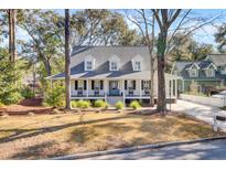 Charming home featuring a cozy front porch, symmetrical design, and mature trees in a desirable neighborhood at 1048 Wharf Indigo Pl, Mount Pleasant, SC 29464