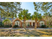 Charming brick home with palm trees in a well-kept yard and beautiful front porch at 17 Guerard Rd, Charleston, SC 29407