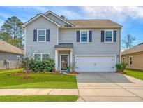 Well-maintained two-story home with attached two-car garage and lush front lawn landscaping at 1932 Zonny Moss Dr, Johns Island, SC 29455