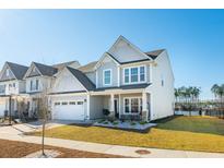 Charming two-story home with a well-manicured lawn, attached garage, and inviting front porch at 247 Godwit Dr, Summerville, SC 29486