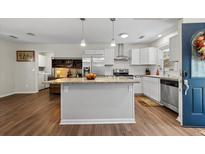 Bright kitchen with a granite island, stainless steel appliances, and white cabinets at 3414 Smoketree Ct, North Charleston, SC 29420
