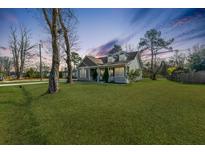 Charming home featuring a well-manicured lawn, inviting porch, and classic architectural details at 5037 Govan Rd, Hollywood, SC 29449