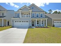 Charming two-story home with a welcoming front porch, two-car garage and beautifully landscaped yard at 599 Red Monarch Way, Moncks Corner, SC 29461