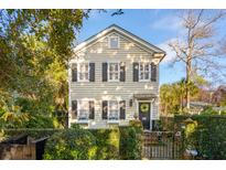 Charming two-story home with tan siding, black shutters, and a well-manicured front yard at 84 1/3 King St # A & B, Charleston, SC 29401