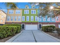 Colorful townhomes, with driveways and nice landscaping, under a sunny blue sky at 9024 Parlor Dr, Ladson, SC 29456