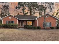 Charming brick home with manicured bushes and dark shutters set against a colorful sunset sky at 101 S Gateshead Crossing, Goose Creek, SC 29445