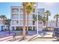 Beachfront hotel features palm trees, benches, and a light-colored facade in a sunny outdoor setting at 1126 Ocean Blvd # 109116230, Isle of Palms, SC 29451
