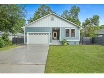 Charming blue home featuring a well-manicured lawn, a one-car garage, and tasteful landscaping at 1565 Juniper St, Charleston, SC 29407