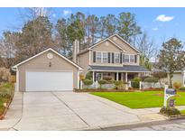 Charming two-story home with a manicured lawn and attached two-car garage at 186 Jupiter Ln, Summerville, SC 29483