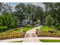 Stunning exterior of home with lush landscaping and a long, winding driveway at 215 Fell Pt, Daniel Island, SC 29492
