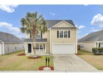 Charming two-story home featuring a palm tree, black shutters, a front porch, and a two-car garage at 315 Bradley Bend Dr, Moncks Corner, SC 29461