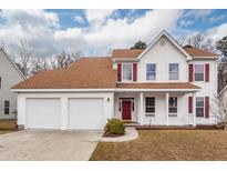Charming two-story home features a two-car garage and a welcoming front porch with red door and shutters at 3388 Forest Glen Dr, Charleston, SC 29414