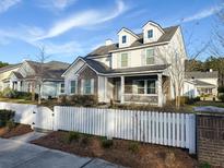 Charming two-story home with brick accents, dormer windows and a welcoming front porch, framed by a white picket fence at 3933 Bessemer Rd, Mount Pleasant, SC 29466