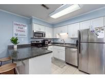 Bright kitchen featuring modern appliances, white cabinets, and a breakfast bar for convenient dining at 40 Bee Street # 314, Charleston, SC 29403