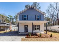 Two-story home with blue and white exterior and a well-maintained front yard and gravel driveway at 405 Simmons Ave, Summerville, SC 29483