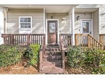 Inviting front porch with wood railings and lush greenery welcomes you home at 4791 Arco Ln, North Charleston, SC 29418