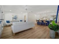 Open-concept living room features modern decor, hardwood floors, and a view of the kitchen island with barstool seating at 519 Bank St, Mount Pleasant, SC 29464