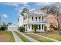 Charming two-story home featuring a double balcony and detached garage with a well-manicured front yard at 8957 N Red Maple Cir, Summerville, SC 29485
