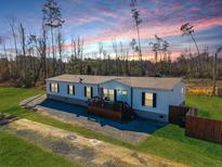 Charming single-story home with a cozy front porch, surrounded by a lush green lawn and mature trees at 1026 Cane Gully Rd, Moncks Corner, SC 29461