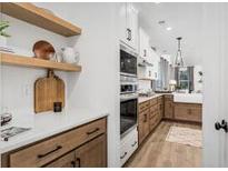 Bright kitchen with stainless steel appliances and white cabinets and modern fixtures at 106 Abbey Terrace Rd, Moncks Corner, SC 29461