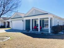 Charming single-story home featuring a welcoming front porch with red rocking chairs and an attached garage at 113 Mayfield Dr, Goose Creek, SC 29445