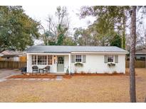 Charming single-story brick home featuring a welcoming front porch and freshly landscaped yard at 1149 Oxbow Dr, Charleston, SC 29412