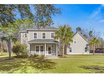 Charming two-story home featuring a welcoming front porch and lush green lawn, perfect for southern living at 144 Clark Ln, Summerville, SC 29483