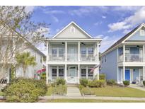 Charming two-story home with double porches, a manicured lawn, and beautiful landscaping at 1523 Star Flower Aly, Johns Island, SC 29455