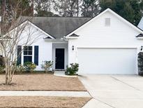 Charming one-story home with a well-manicured lawn, black front door and a two-car garage at 2117 Colson Ln, Johns Island, SC 29455