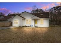 Charming single-story home with white siding and a well-maintained front yard at dusk at 311 Macgregor Dr, Summerville, SC 29486