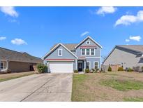Charming blue two-story home with red accents, a well-kept lawn, and a two-car garage at 317 Bountiful Dr, Moncks Corner, SC 29461