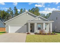 Charming home featuring a manicured lawn, attached garage, and a covered front porch at 4316 Cotton Flat Rd, Summerville, SC 29485