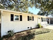 Charming white brick home with black shutters and a well-manicured front yard at 4774 Linda St, North Charleston, SC 29405