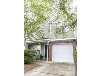 Charming two-story home featuring a brick-accented garage and inviting front porch with lush landscaping at 5208 Fernland Way, North Charleston, SC 29420