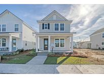 Charming two-story home featuring a welcoming front porch and well-manicured lawn at 722 Rumbling Leaf Ln, Summerville, SC 29486