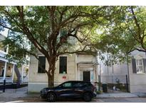 Two-story exterior with mature tree and black SUV parked in front at 125 Wentworth St, Charleston, SC 29401