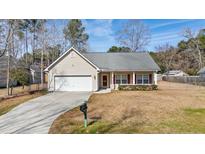 Charming one-story home featuring a well-manicured front yard and an attached two-car garage at 144 Cinnamon Rd, Summerville, SC 29483