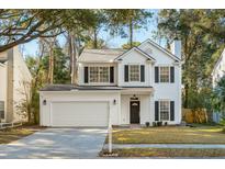 Charming two-story traditional home featuring a two-car garage, black shutters, and mature trees at 1582 Harborsun Dr, Charleston, SC 29412