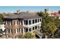 Stunning exterior view of a historic home, showcasing balconies, columns, and surrounding foliage at 214 Calhoun St # 5, Charleston, SC 29401