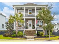 Charming home featuring double porches, palm trees, and manicured landscaping at 2648 Augustus St, Daniel Island, SC 29492