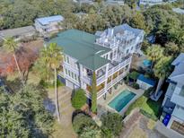 Expansive aerial view of a charming two-story home with a private pool, balconies, and lush landscaping at 4000 Cameron Blvd, Isle of Palms, SC 29451