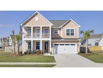 Charming two-story home with a spacious front porch and well-manicured lawn at 661 Black Pine Rd, Moncks Corner, SC 29461