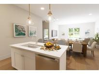 Bright open concept kitchen with stainless steel appliances and eat-in island flowing into dining area at 7631 Indigo Palms Way, Johns Island, SC 29455